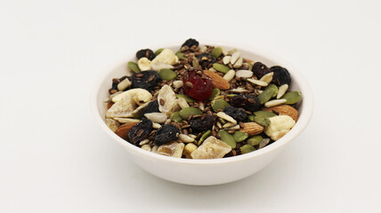 Healthy trail mix snack made of nuts (walnut, almond, peanut) and dried fruits (raisin, sultana) on iron scoop (Selective Focus, Focus on the front of the almond)