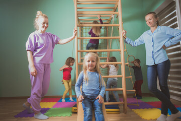 Teacher supports children during active games at preschool