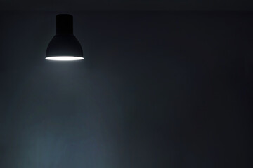 a shining levitating hanged ceiling lamp without electric wire  with dark blue tone dirty concrete background wall.