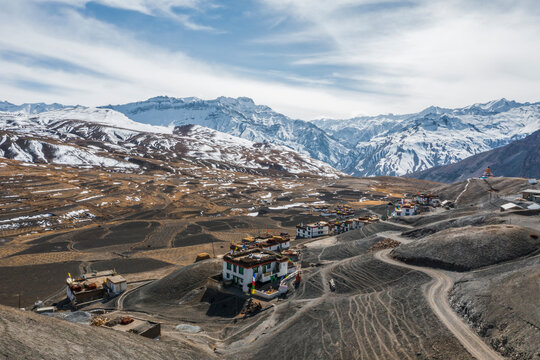 Aerial view of scattered houses on a desert landscape with agricultural fields on mountain top at wintertime near Kaza township, Himachal Pradesh, India.