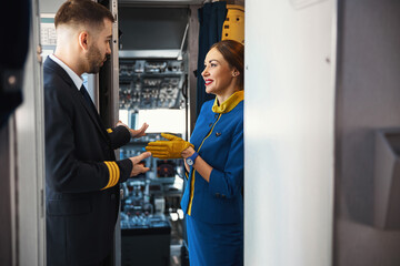 Friendly colleagues in the aircraft communicating and smiling