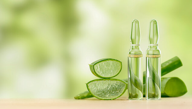 aloe vera extract in ampoules on a wooden table. natural cosmetic
