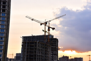 Fototapeta premium Tower crane on construction of a residential building. Cranes on formworks. Construction the building or multi-storey homes. Instal concrete wall rebar. Renovation concept. Realtor and Real Estate