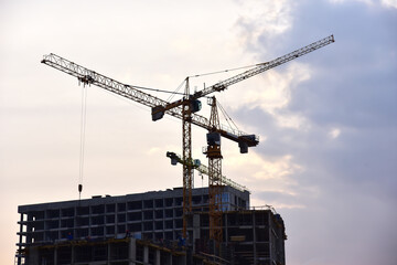 Tower crane on construction of a residential building. Cranes on formworks. Construction the building or multi-storey homes. Instal concrete wall rebar. Renovation concept. Realtor and Real Estate