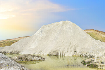 Chalk structure on artificial mountain after quarry mining. Technogenic rock formed during mine. Mountain hill with chalk fossil and limestone. Mining geology. Canyon with mountains in open pit