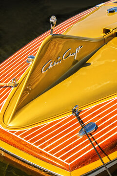 04_02_2009 Tulsa OK USA Close-up detail of yellow fin of Chris Craft teak retro speedboat with logo tie to dock in water.