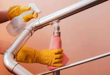 Close-up of a woman cleaning the stair railing. Spring cleaning, disinfection in coronavirus, service