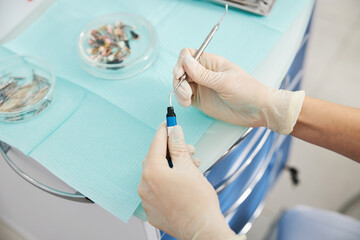 Medic putting dental plugger into composite resins vial
