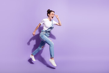Fototapeta na wymiar Full length profile side photo of young girl happy smile jump go walk run hurry isolated over violet color background