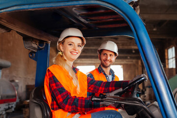 Happy woman forklift driver smiling, looking at the camera