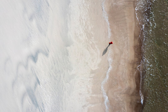 Aerial view of a person walking on the beach near Baltic sea in Klaipeda, Lithuania.