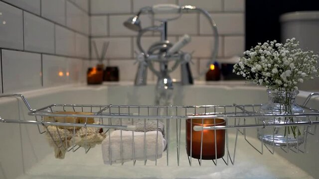 Slow motion footage of relaxing bath ritual from point of view in the bath water. Candles, bath salts and essential oils to create restorative, meditative atmosphere. Self care and mindfulness concept