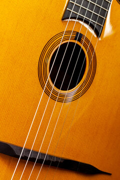 Gros plan sur la table d'harmonie, les cordes d'une guitare acoustique manouche