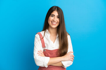 Young caucasian woman isolated on blue background keeping the arms crossed in frontal position