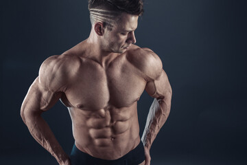 Fototapeta na wymiar Strong Athletic Sexy Muscular Man on Black Background