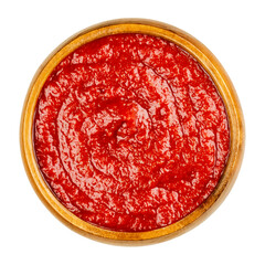 Homemade tomato ketchup in a wooden bowl. Red sweet and tangy table condiment, made from tomato paste, sugar, vinegar and seasonings, served to fried or greasy dishes. Close-up from above, food photo.