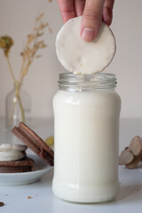vaso de leche fresca con alfajores rellenos de dulce de leche y cobertura de chocolate blanco...