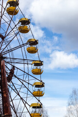 Old abandoned rusty metal radioactive yellow ferris wheel against dramatic sky in amusement park in ghost town Pripyat, Chernobyl Exclusion Zone