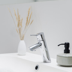 Close-up on silver tap in bathroom washbasin