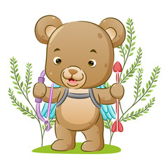 The cute cupid bear is holding the arrow love on her hand and standing in the park