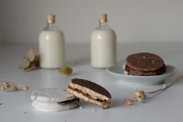 glass of milk with dulce de leche alfajores covered with black and white chocolate, typical food of Argentina