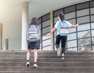 Back to school, children education concept with girl kids or elementary student carrying backpacks going, running to class on school first day and walking up building stair happily