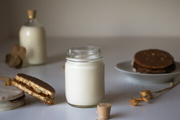 glass of milk with dulce de leche alfajores covered with black and white chocolate, typical food of Argentina