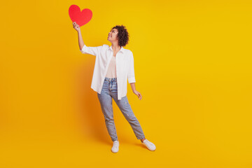 Portrait of girl with red paper heart figure look up empty space