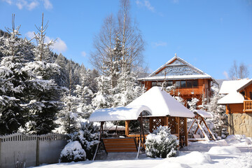 Picturesque view of wooden cabin and beautiful forest covered with snow in winter
