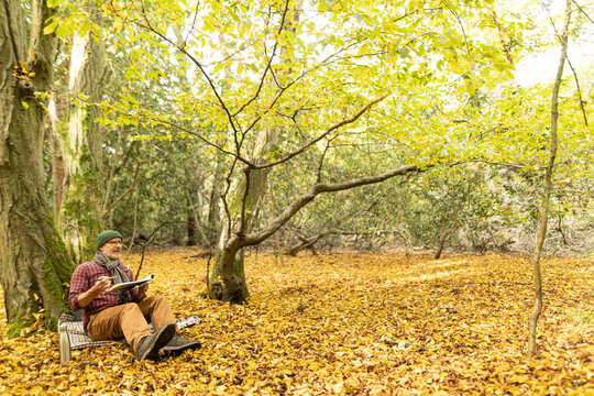 UK, London, Epping Forest, Man painting in Autumn landscape