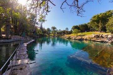 A huge pool of clear turquoise water, in Gan Hashlosha Park in the Beit She'an Valley