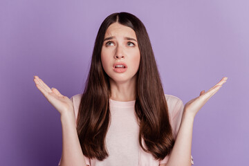 Portrait of sad unhappy woman raise palms look empty space isolated on violet background