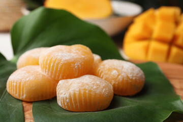 Delicious mochi with green leaf on wooden board, closeup. Traditional Japanese dessert