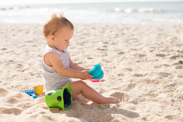 Baby playing on the sandy beach near the sea