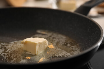 Frying pan with melted butter on stove, closeup