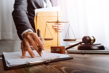 Justice and law concept.Male judge in a courtroom with the gavel, working with, computer and...