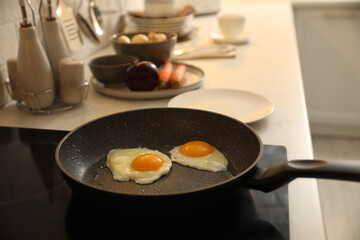 frying pan with fresh eggs on cooktop