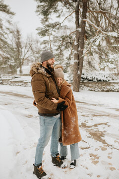 Canada, Ontario, Hugging couple standing on snowy road