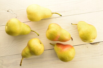 Fototapeta na wymiar Several juicy ripe, light yellow pears, on a wooden table, close-up, top view.