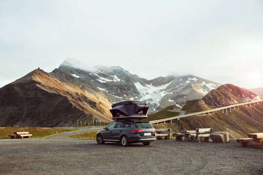 Italy, Austria, Car with tent on roof in mountain landscape
