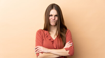 Obraz premium Young caucasian woman isolated on beige background with unhappy expression