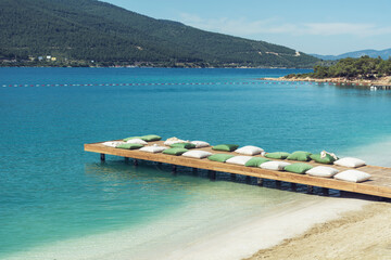 Wooden Pier with Big Pillows in the Sea .Summer Holiday