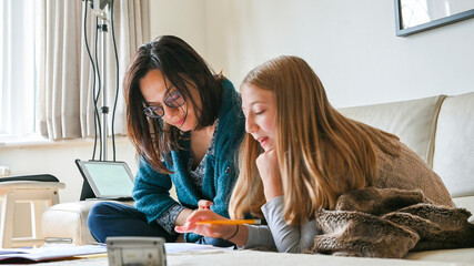 UK, Surrey, Mother helping daughter with homework