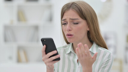 Fototapeta na wymiar Portrait of Upset Young Woman having Loss on Smartphone 