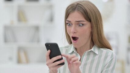 Portrait of Excited Young Woman in Wonder Using Smartphone 
