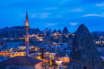 Naklejka premium Landscape of the night city of Goreme, Cappadocia Turkey, overlooking the minaret and houses in the rocks, .blue hour