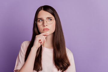 Photo of girl minded mood finger chin look empty space posing on purple background