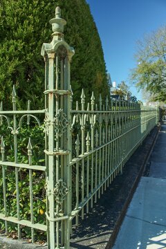 A green wrought iron fence