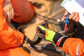Hand of an operation staff is holding pressure hose line's connection for inspecting the condition,...