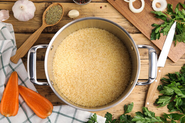 Flat lay composition with dry rice in wok on wooden table